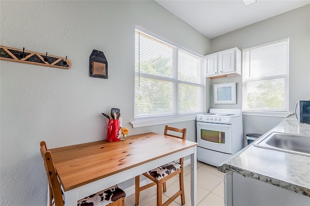 kitchen featuring white cabinetry, white range with electric cooktop, and plenty of natural light