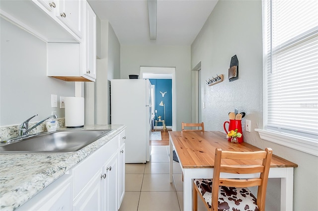 kitchen featuring white cabinets, white appliances, plenty of natural light, and sink