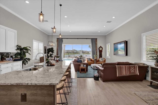 kitchen featuring decorative light fixtures, a healthy amount of sunlight, and white cabinetry