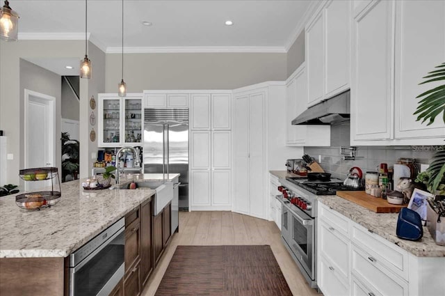 kitchen with white cabinets, a center island with sink, high quality appliances, and light hardwood / wood-style floors