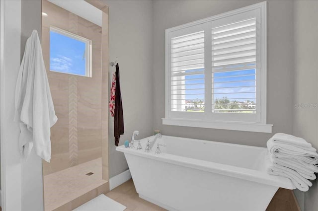 bathroom featuring shower with separate bathtub and tile patterned flooring