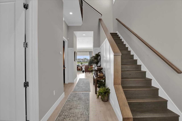 staircase with hardwood / wood-style flooring and a high ceiling