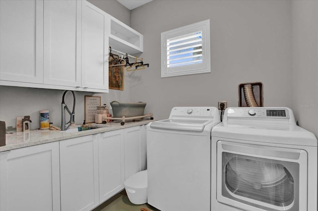 washroom with washer and clothes dryer, cabinets, and sink