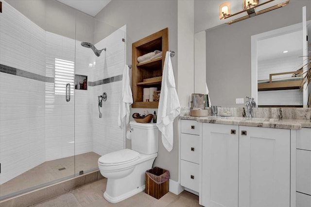 bathroom with a shower with door, vanity, and toilet