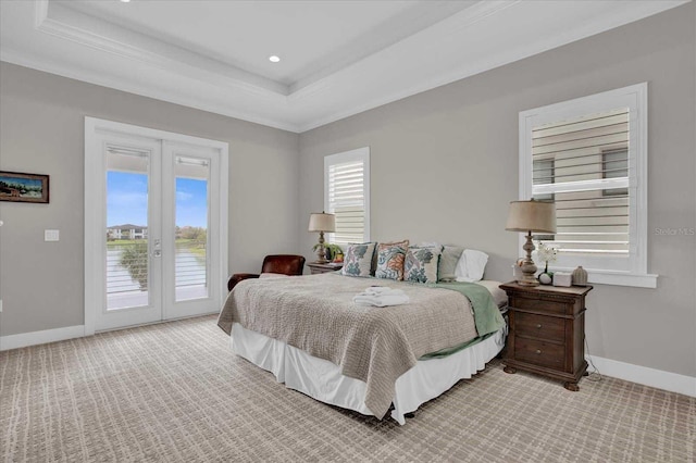 bedroom with a raised ceiling, light colored carpet, and access to exterior