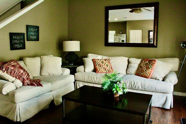 living room featuring ceiling fan and dark hardwood / wood-style flooring