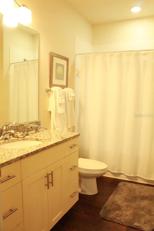 bathroom featuring vanity, hardwood / wood-style floors, and toilet