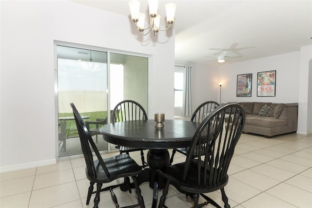 tiled dining area with ceiling fan with notable chandelier