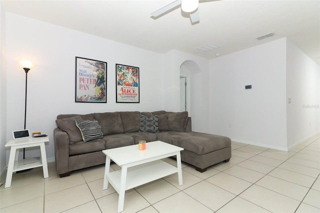 living area featuring light tile patterned floors, ceiling fan, arched walkways, baseboards, and visible vents