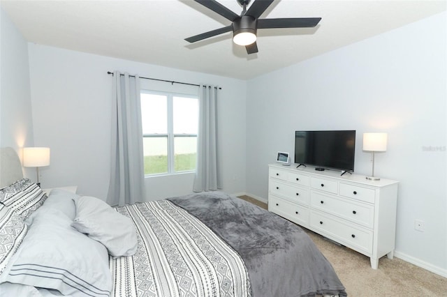 bedroom featuring light carpet, baseboards, and ceiling fan