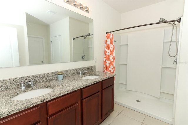 bathroom featuring tile patterned floors, a sink, double vanity, and curtained shower