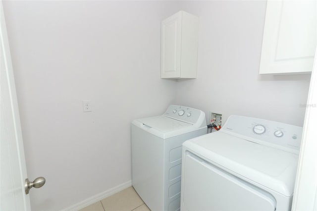 laundry room featuring cabinets, washer and dryer, and light tile patterned flooring