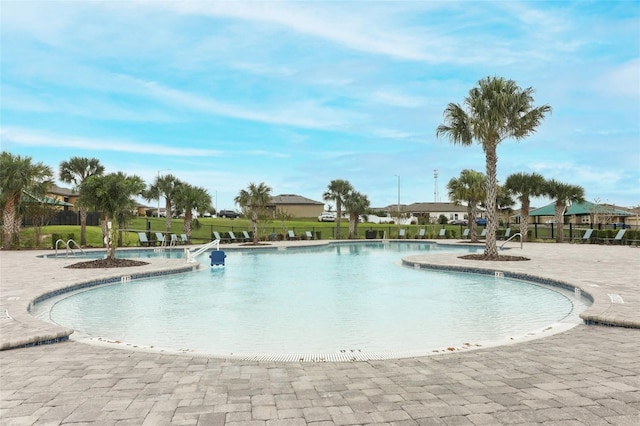 pool featuring fence and a patio area