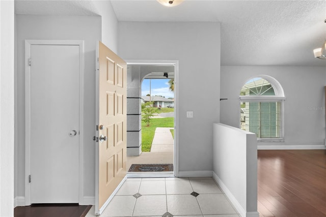 entrance foyer with light wood-type flooring and a textured ceiling