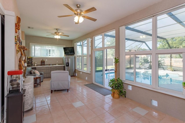 living room featuring light tile patterned floors, ceiling fan, a healthy amount of sunlight, and sink