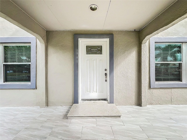 entrance to property with stucco siding