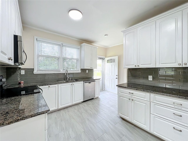 kitchen featuring stainless steel appliances, sink, dark stone counters, and white cabinetry