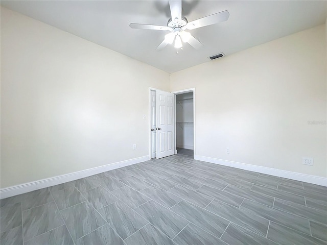 spare room featuring baseboards, visible vents, and a ceiling fan