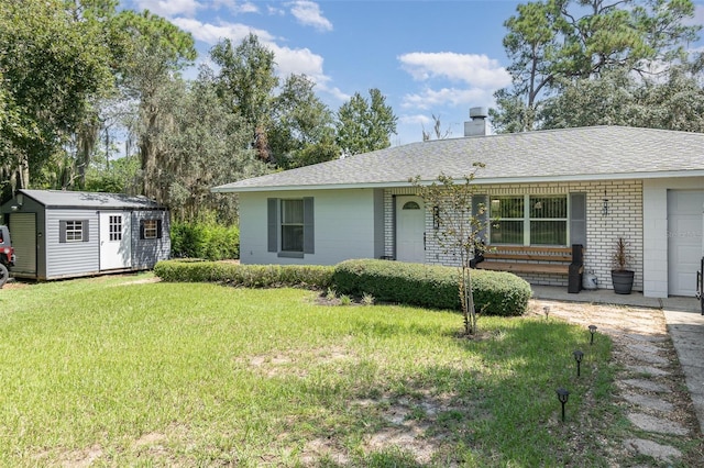 single story home with a shed, a front lawn, and a garage