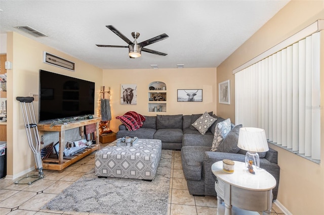 living room featuring ceiling fan, light tile patterned floors, and a textured ceiling