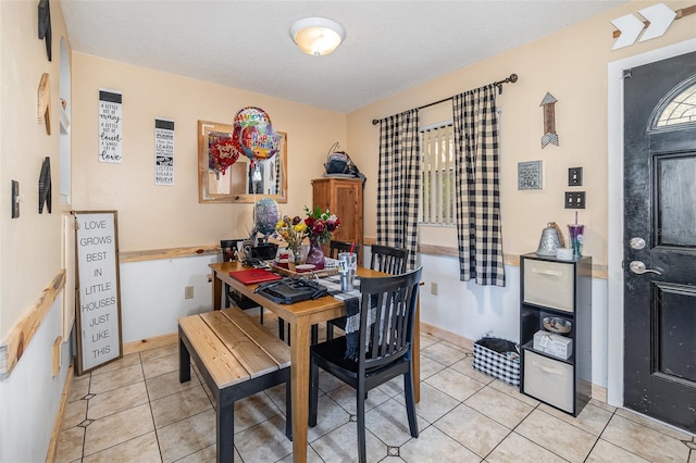 dining area featuring a textured ceiling and light tile patterned floors