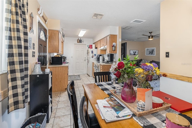 tiled dining room with ceiling fan and a textured ceiling