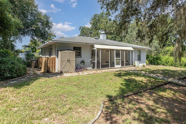 back of house with a lawn and a sunroom