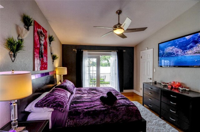 bedroom with access to exterior, baseboards, ceiling fan, vaulted ceiling, and wood finished floors