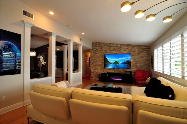 cinema room with decorative columns, wood finished floors, and visible vents
