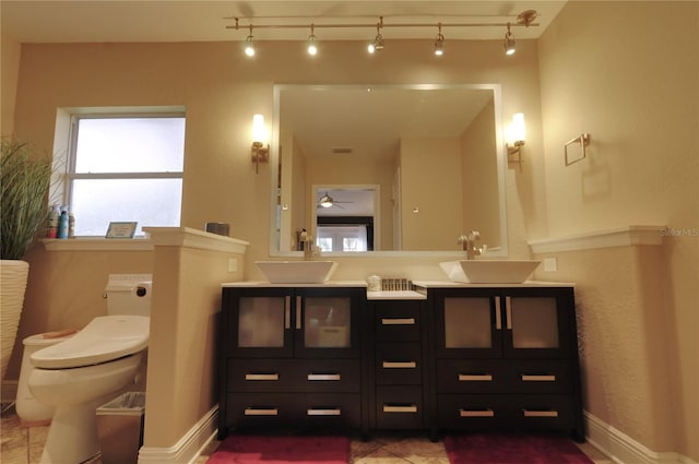 bathroom with rail lighting, vanity, ceiling fan, toilet, and tile patterned floors