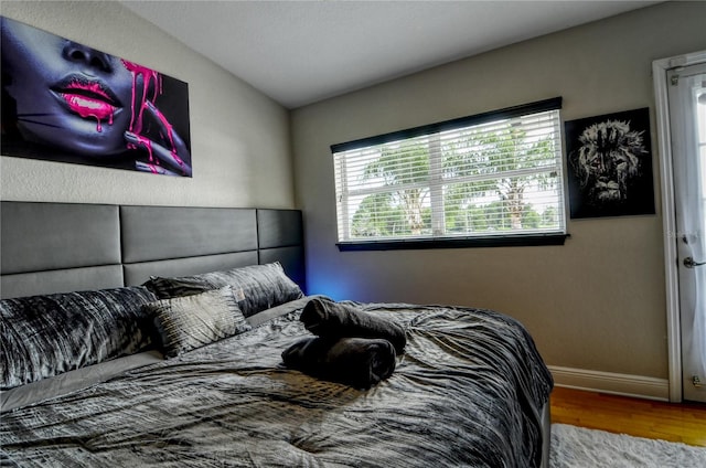 bedroom with light hardwood / wood-style flooring and vaulted ceiling