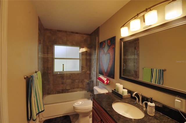 full bathroom with tiled shower / bath, vanity, and toilet