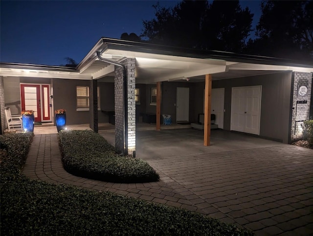 exterior space featuring stucco siding, an attached carport, and driveway