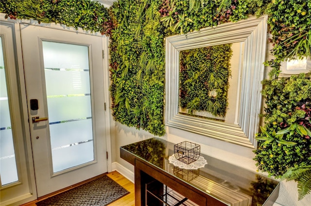 entryway featuring baseboards, light wood-style floors, and wallpapered walls