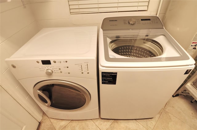 washroom with light tile patterned floors, laundry area, and washer and clothes dryer