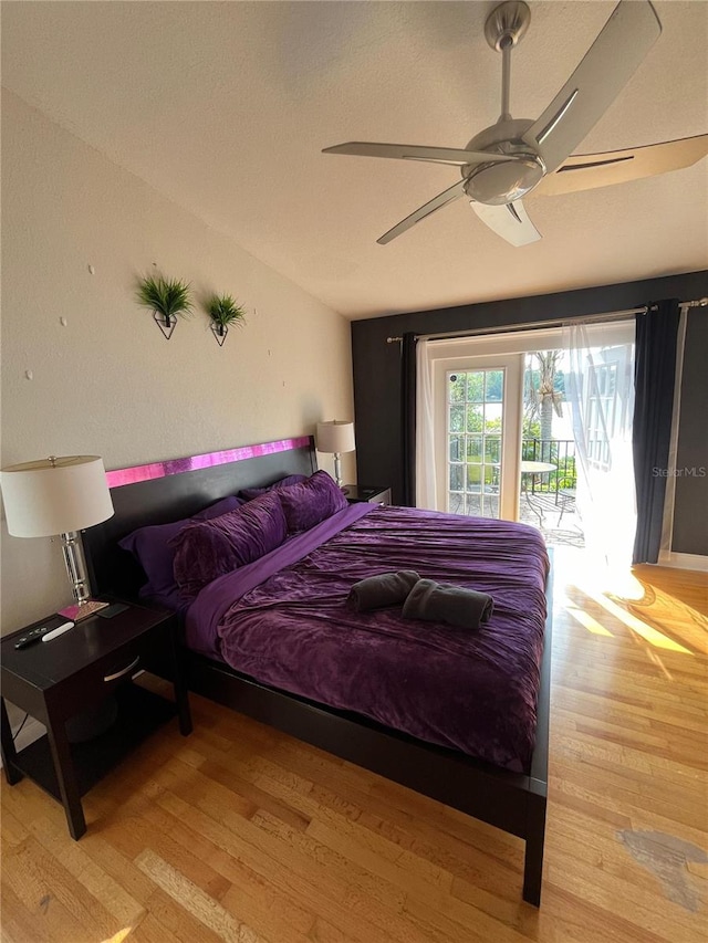 bedroom with ceiling fan, wood finished floors, and access to exterior