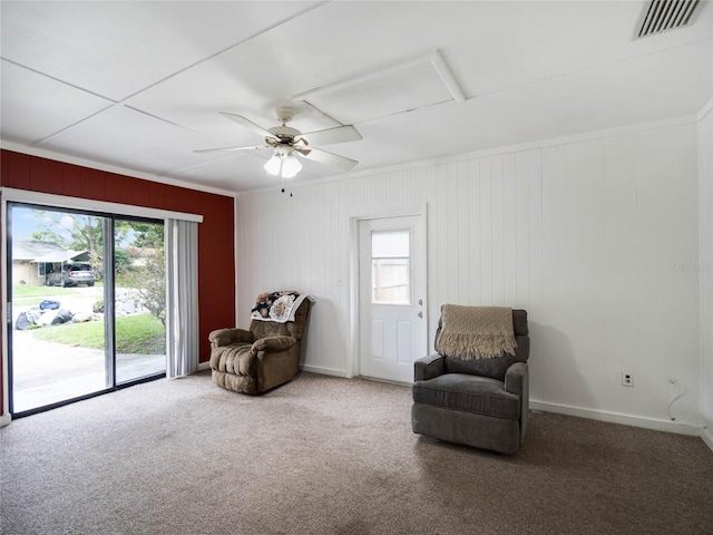 sitting room with a wealth of natural light, ceiling fan, carpet flooring, and crown molding