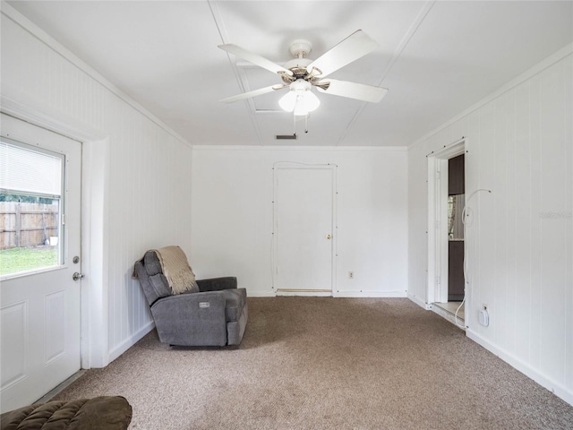 living area featuring ornamental molding, ceiling fan, and carpet floors