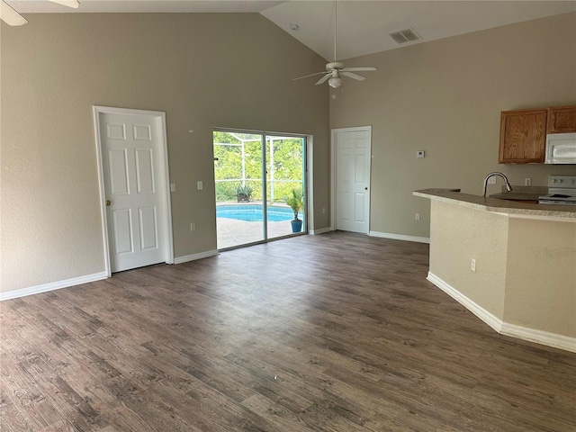 interior space with dark hardwood / wood-style floors, ceiling fan, sink, and high vaulted ceiling