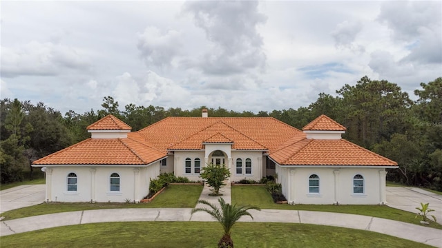 mediterranean / spanish home with a front yard