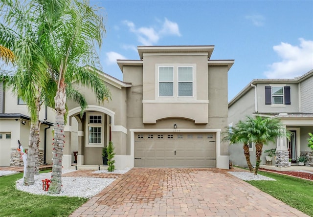 2599 Nouveau Way, Kissimmee, FL 34741 - view of front of house with stucco siding, decorative driveway, and a garage