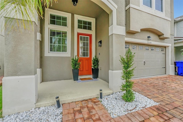 2599 Nouveau Way, Kissimmee, FL 34741 - property entrance with stucco siding, decorative driveway, and a garage
