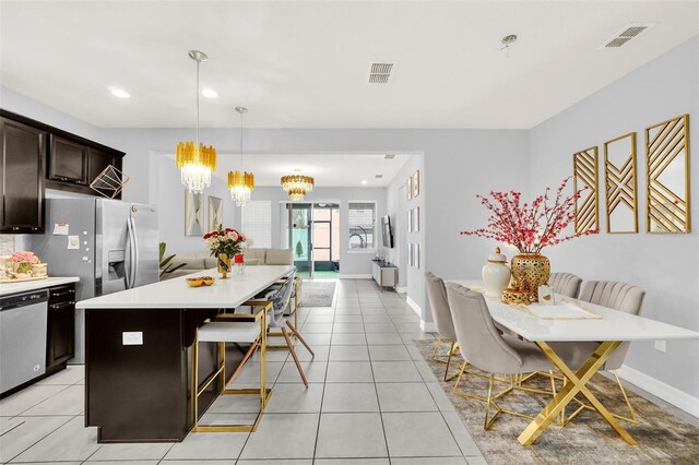 kitchen with dark brown cabinetry, pendant lighting, a kitchen island, appliances with stainless steel finishes, and a breakfast bar