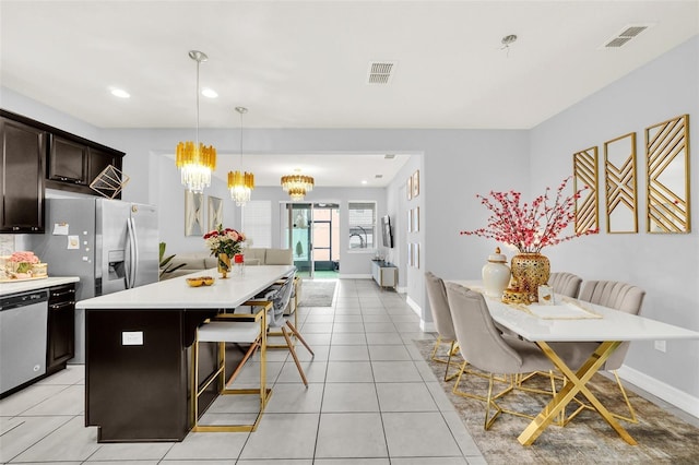 2599 Nouveau Way, Kissimmee, FL 34741 - kitchen featuring visible vents, light countertops, dark brown cabinetry, appliances with stainless steel finishes, and a notable chandelier