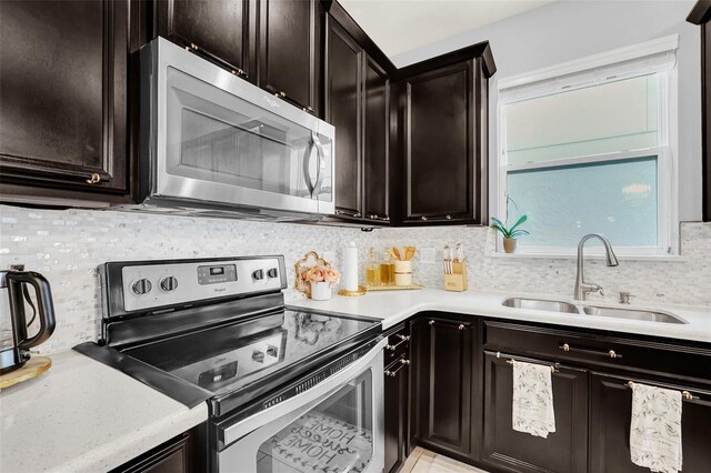 kitchen with dark brown cabinetry, sink, stainless steel appliances, and tasteful backsplash