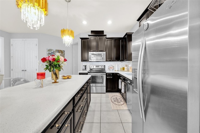 2599 Nouveau Way, Kissimmee, FL 34741 - kitchen featuring an inviting chandelier, light tile patterned flooring, stainless steel appliances, light countertops, and backsplash