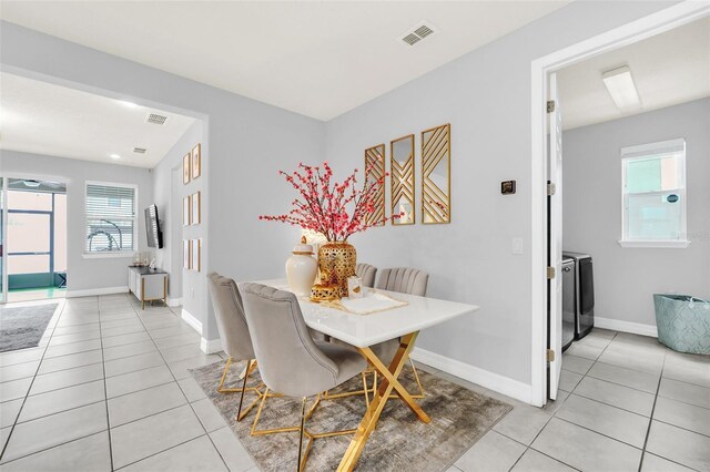 tiled dining area with washer and clothes dryer