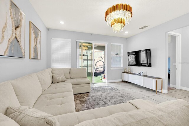 living room featuring an inviting chandelier, plenty of natural light, and light tile patterned floors