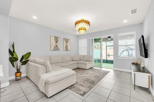 tiled living room featuring ceiling fan with notable chandelier