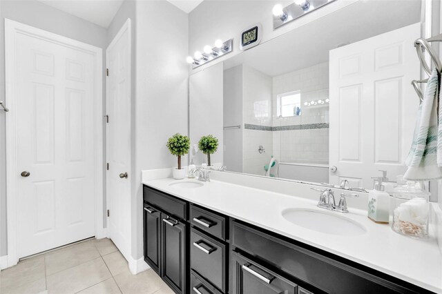 bathroom featuring tile patterned flooring, vanity, and tiled shower